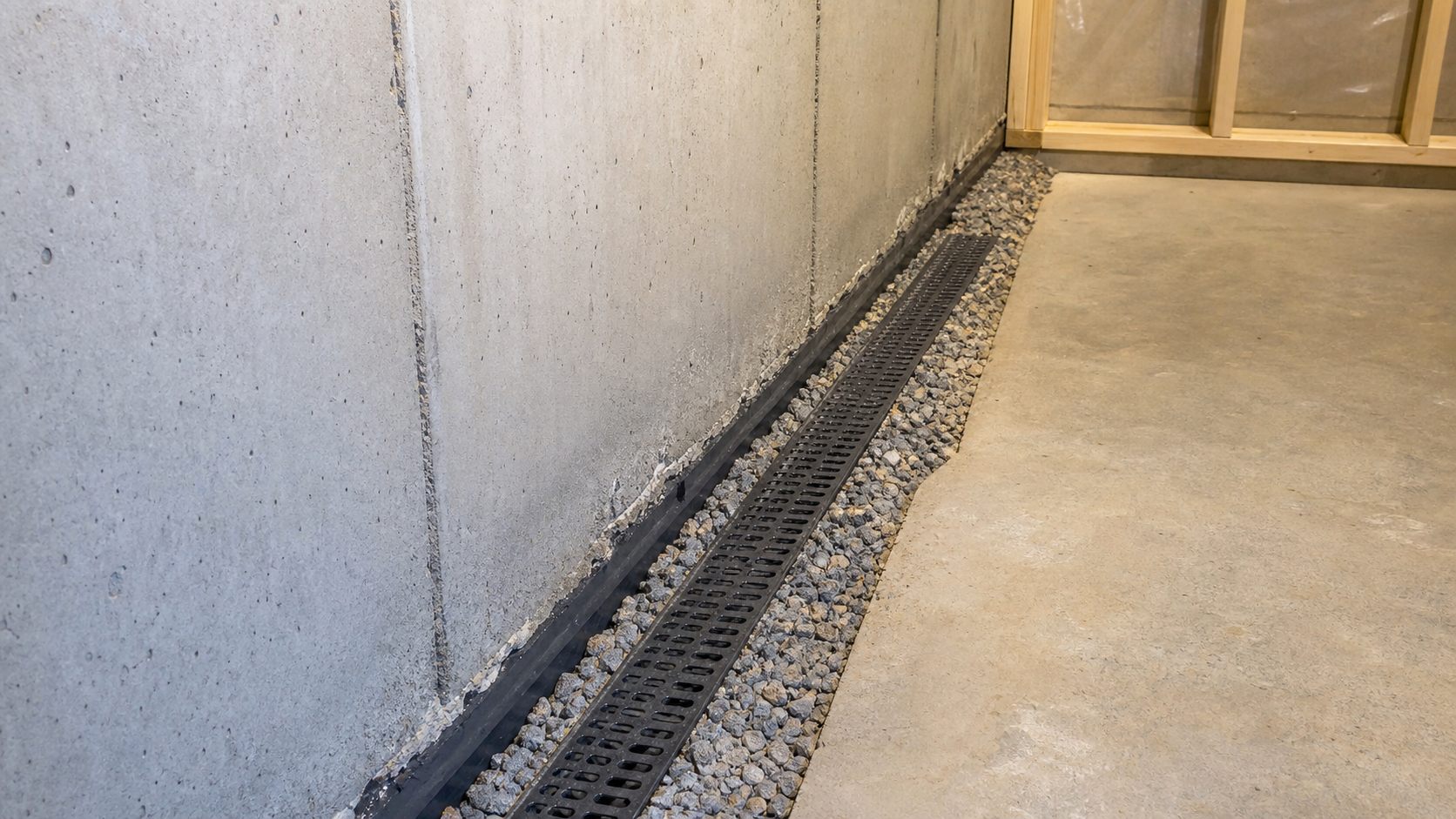 Interior drain tile channel and waterproofing detail along a Duluth-area basement foundation wall